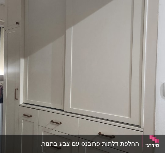 ארונות מטבח עם ידיות מתכת על רצפת עץ